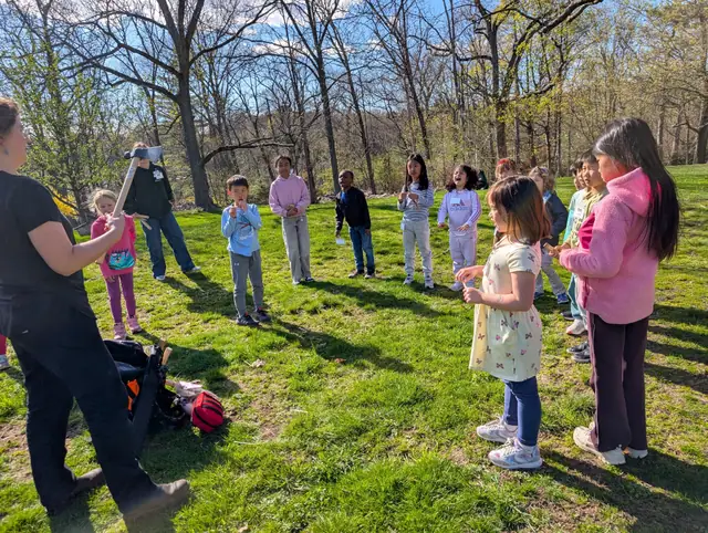 Kids and instructors gather on a school field on a spring afternoon.