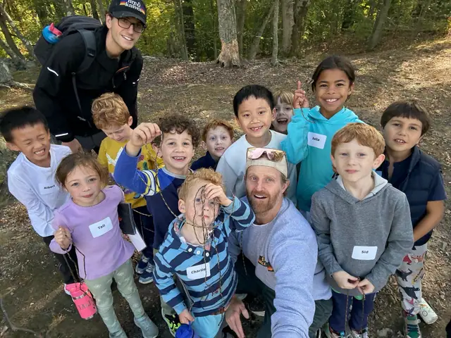 An instructor shows a group of kids a knot, everyone holding their own length of rope.