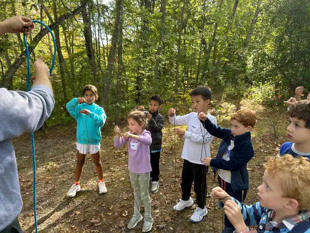 Kids practice tying a rope around a fallen branch.