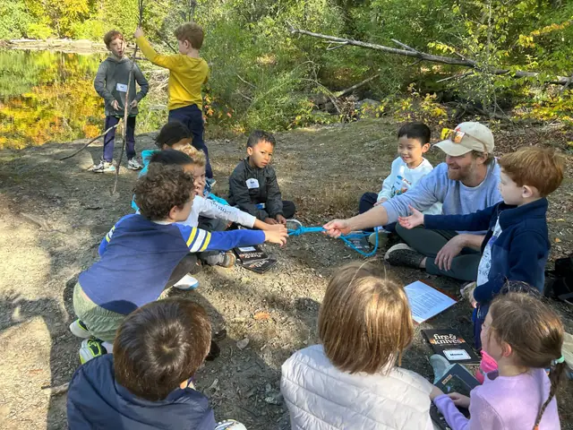 Kids and an instructor test a knot with a tug-of-war on a rope.
